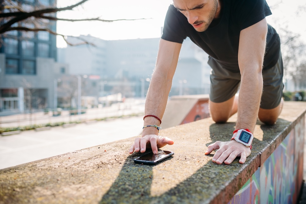 Young sportive man outdoors training using Caliverse mobile app